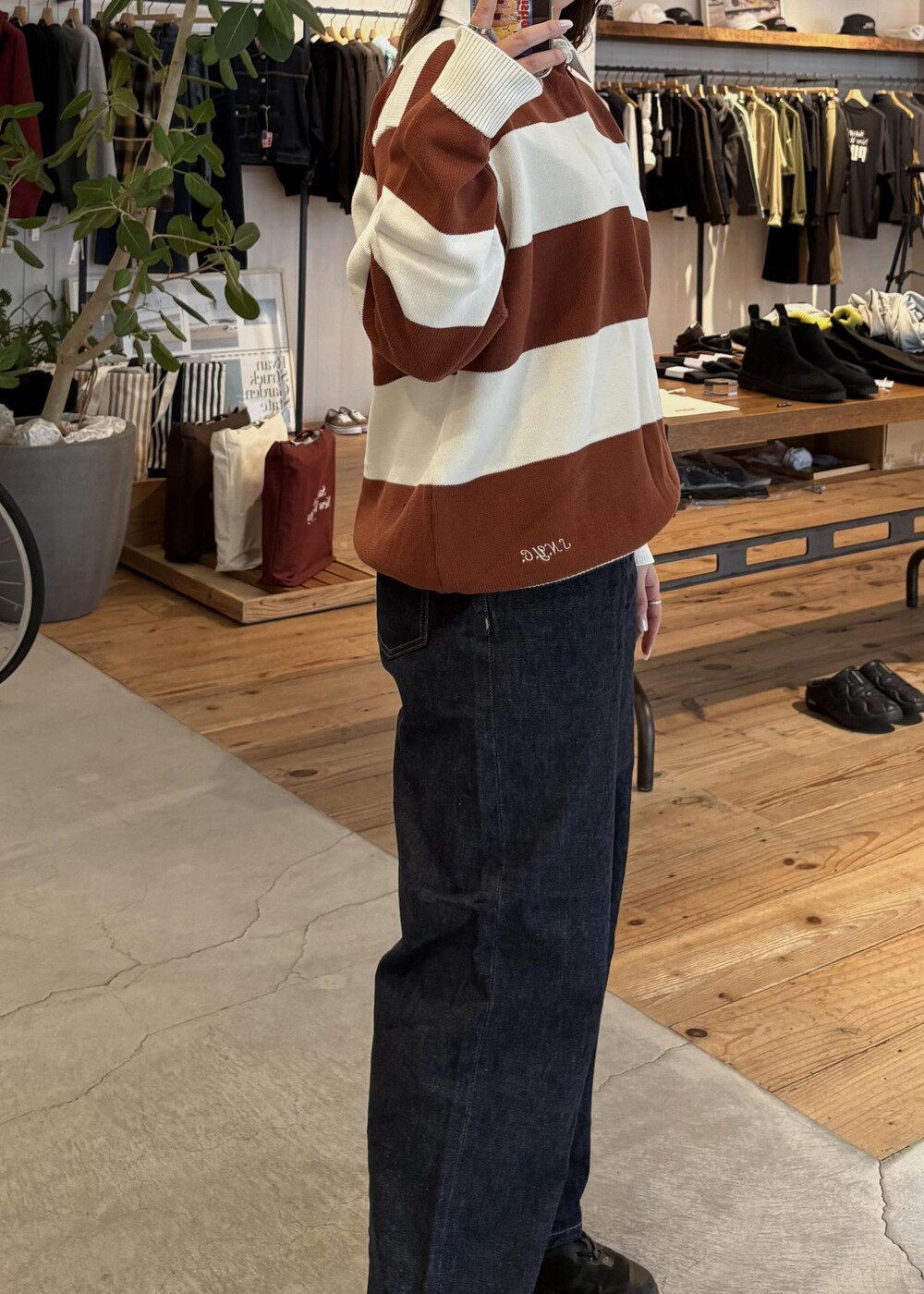 ブルー系のデニムパンツ、オレンジ系のスウェット、ホワイト系のキャップを着用したレディースの冬コーディネートの7枚目の写真