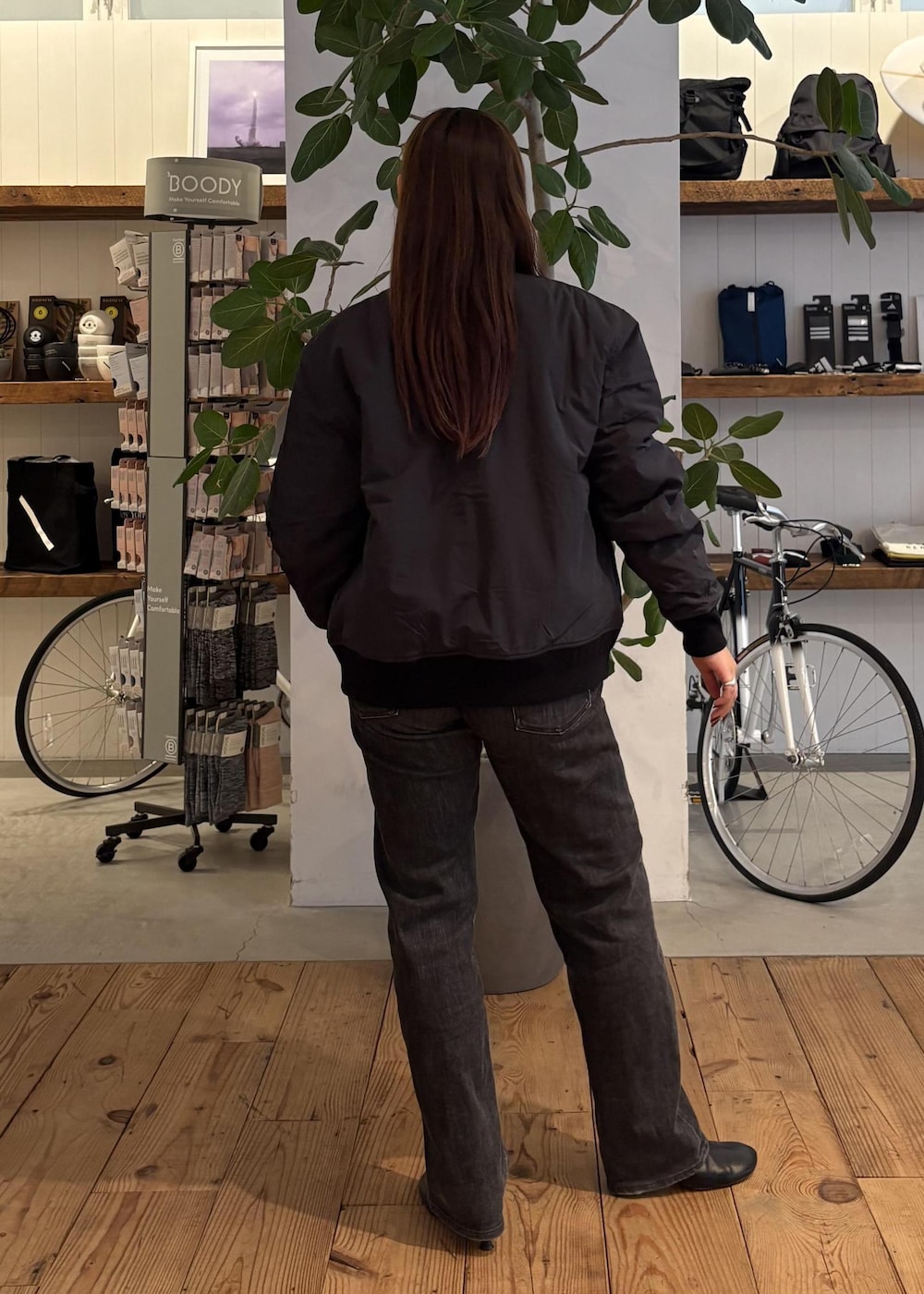 ブラック系のブルゾン、ホワイト系のTシャツ/カットソー、ブラック系のサングラスを着用したレディースの冬コーディネートの3枚目の写真