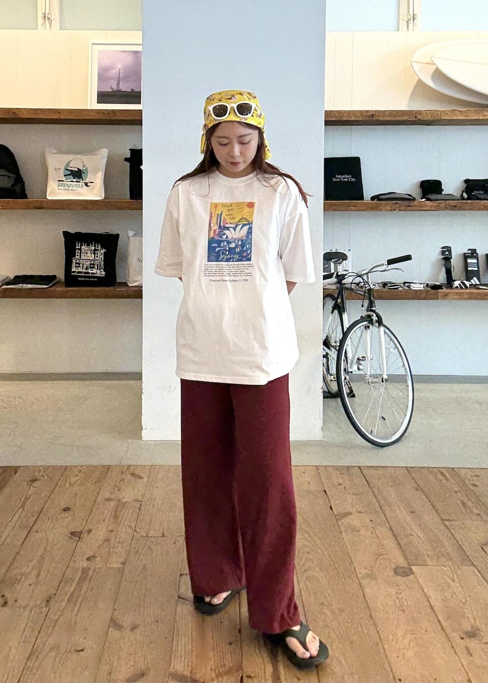 ブラック系のサンダル、ホワイト系のTシャツ/カットソー、レッド系のその他パンツを着用したレディースの夏コーディネートの6枚目の写真