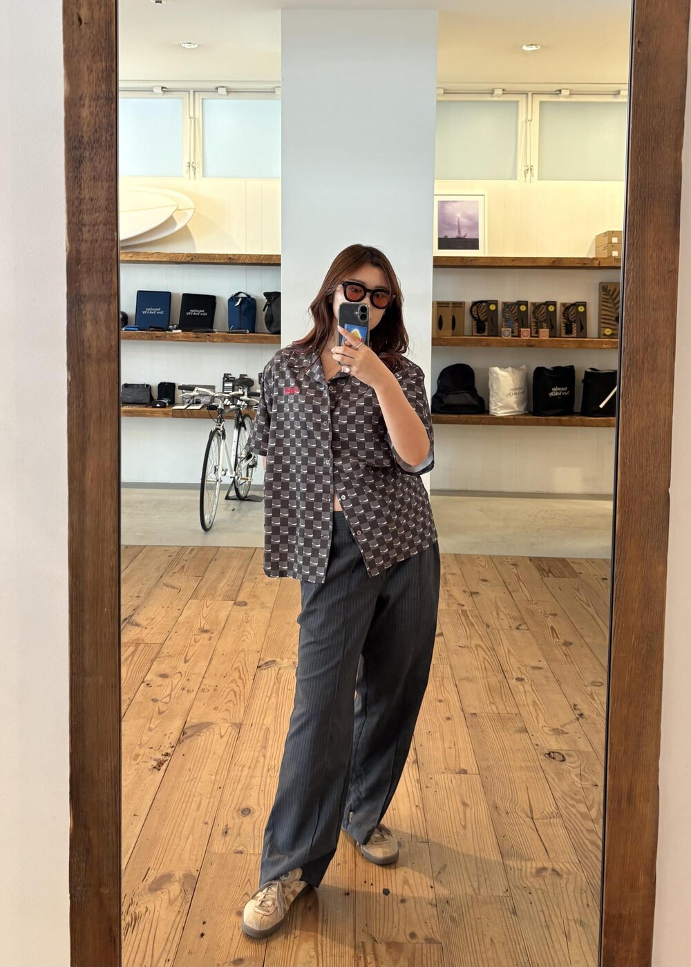 レッド系のTシャツ/カットソー、ブラック系のシャツ/ブラウス、ブラック系のサングラスを着用したレディースの夏コーディネートの6枚目の写真