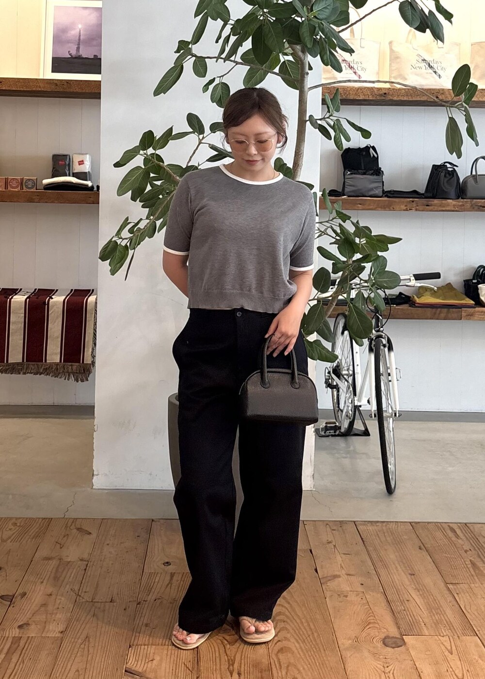 ブラック系のハンドバッグ、ブルー系のチノパンツ、グレー系のTシャツ/カットソーを着用したレディースの夏コーディネートの5枚目の写真
