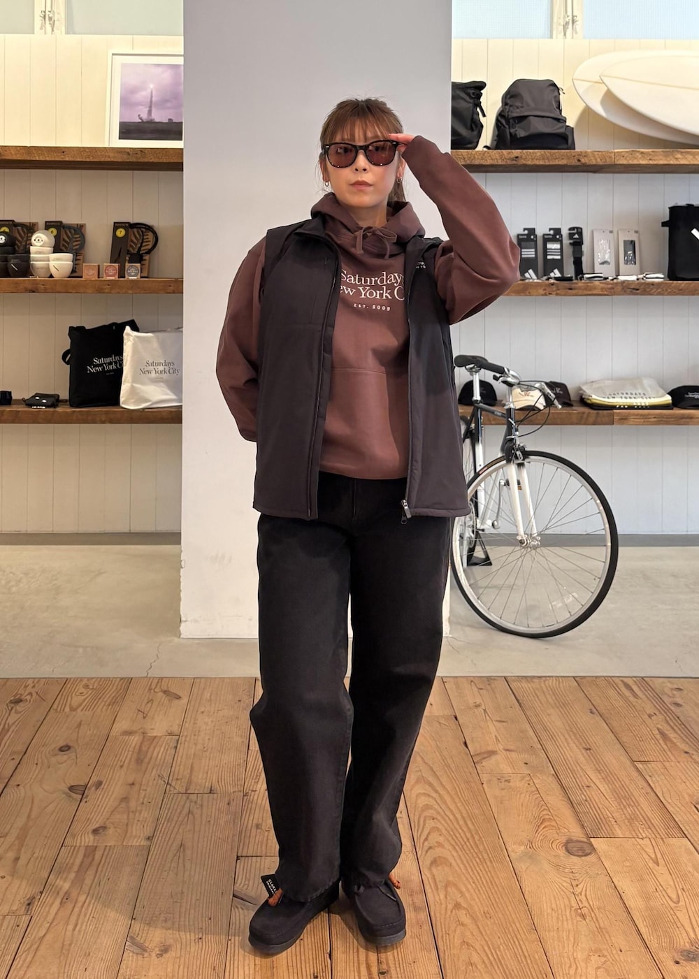 ブラック系のデニムパンツ、グリーン系のダウンジャケット/コート、ブラウン系のパーカーを着用したレディースの冬コーディネートの3枚目の写真