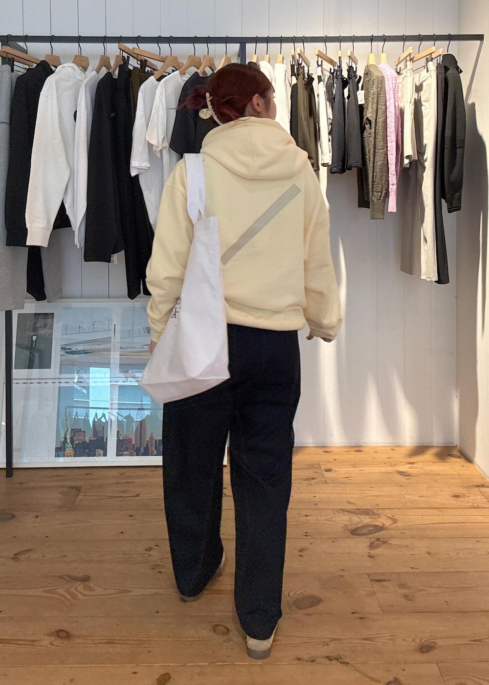 ベージュ系のパーカー、ホワイト系のトートバッグ、ブルー系のその他パンツを着用したレディースの春コーディネートの3枚目の写真