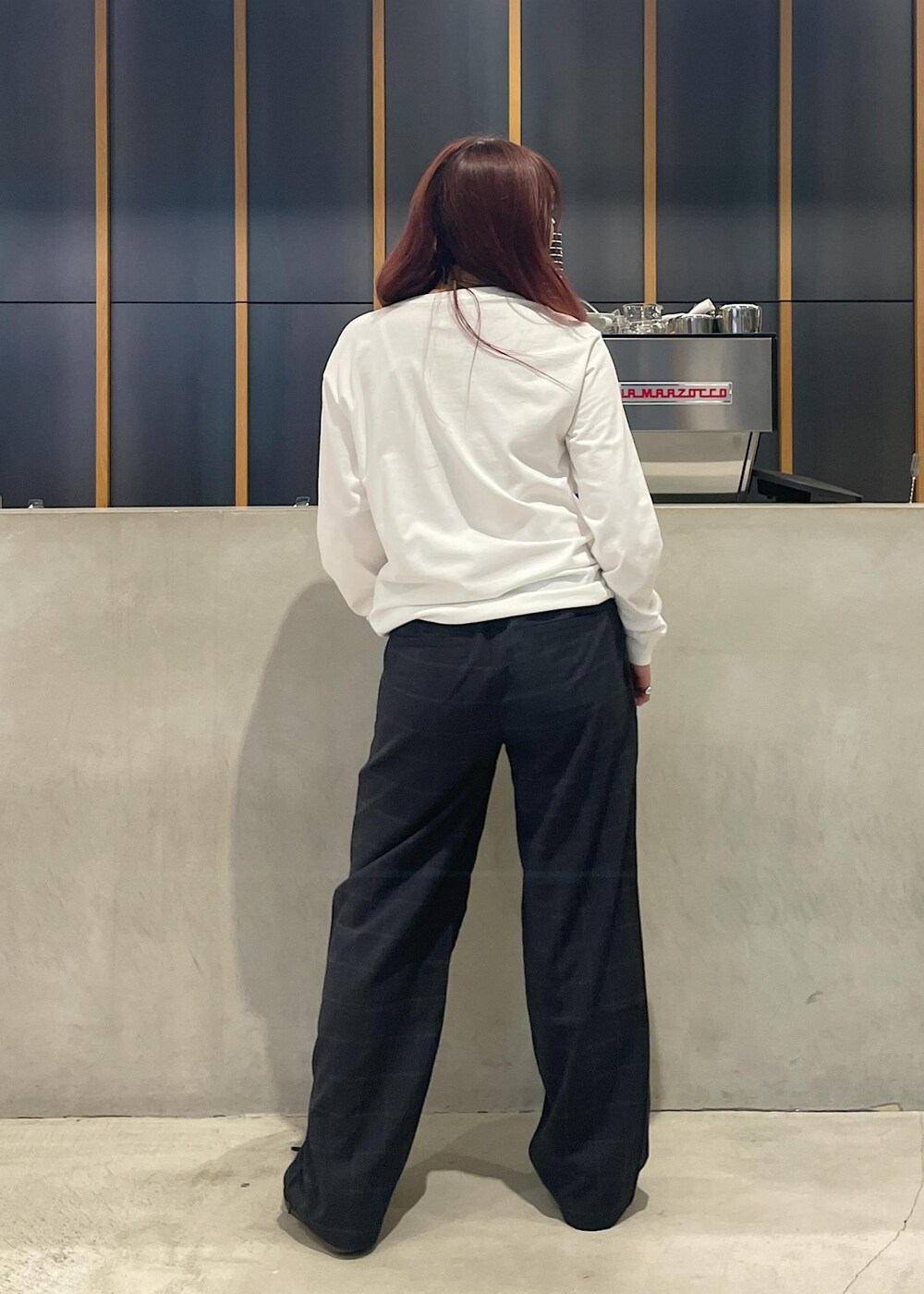 ホワイト系のTシャツ/カットソー、ブラック系のダウンベスト、ブラック系のその他パンツを着用したレディースの秋コーディネートの4枚目の写真