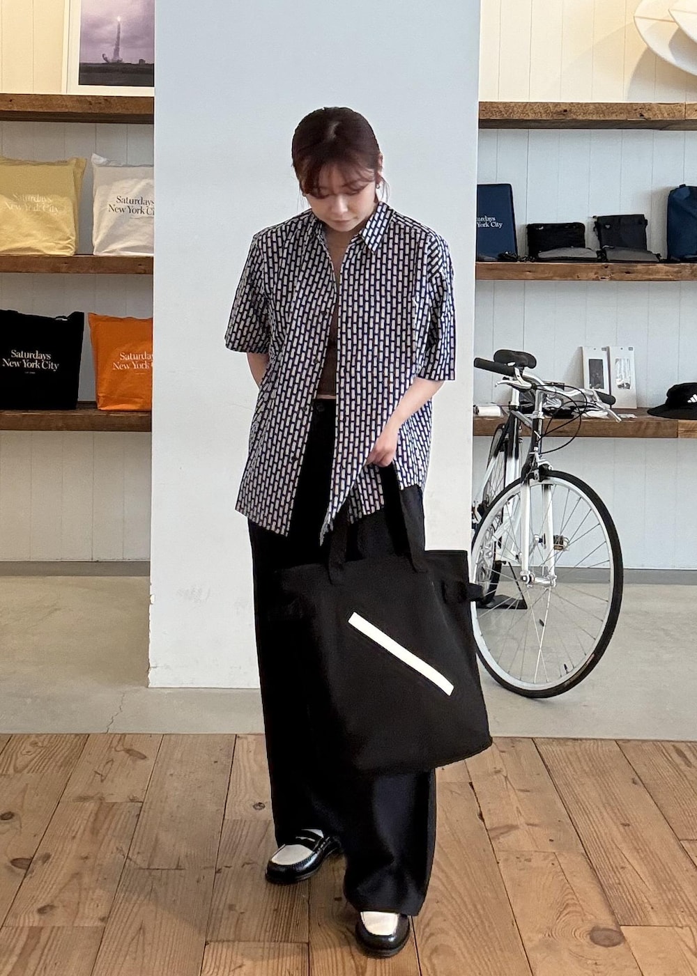 ブラック系のトートバッグを着用したレディースの春コーディネートの3枚目の写真