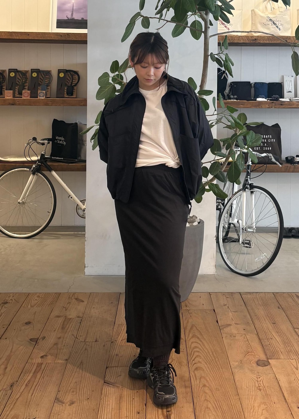 ブラック系のスカート、ブラック系のブルゾン、ホワイト系のTシャツ/カットソーを着用したレディースの春コーディネートの5枚目の写真