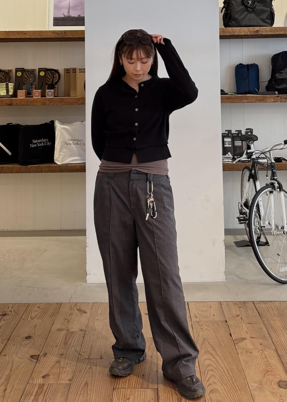 グレー系のスラックス、ブラック系のカーディガン/ボレロ、ブラウン系のサングラスを着用したレディースの秋コーディネートの3枚目の写真