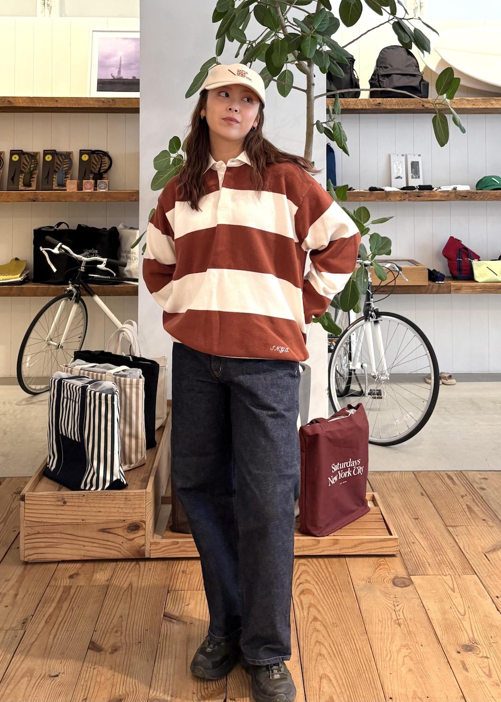 ブルー系のデニムパンツ、オレンジ系のスウェット、ホワイト系のキャップを着用したレディースの冬コーディネートの2枚目の写真