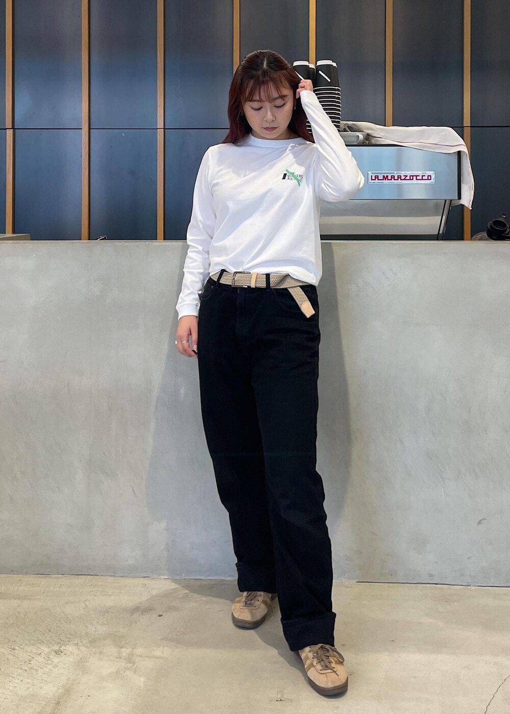 ブラック系のデニムパンツ、ホワイト系のTシャツ/カットソー、ベージュ系のベルトを着用したレディースの秋コーディネートの2枚目の写真