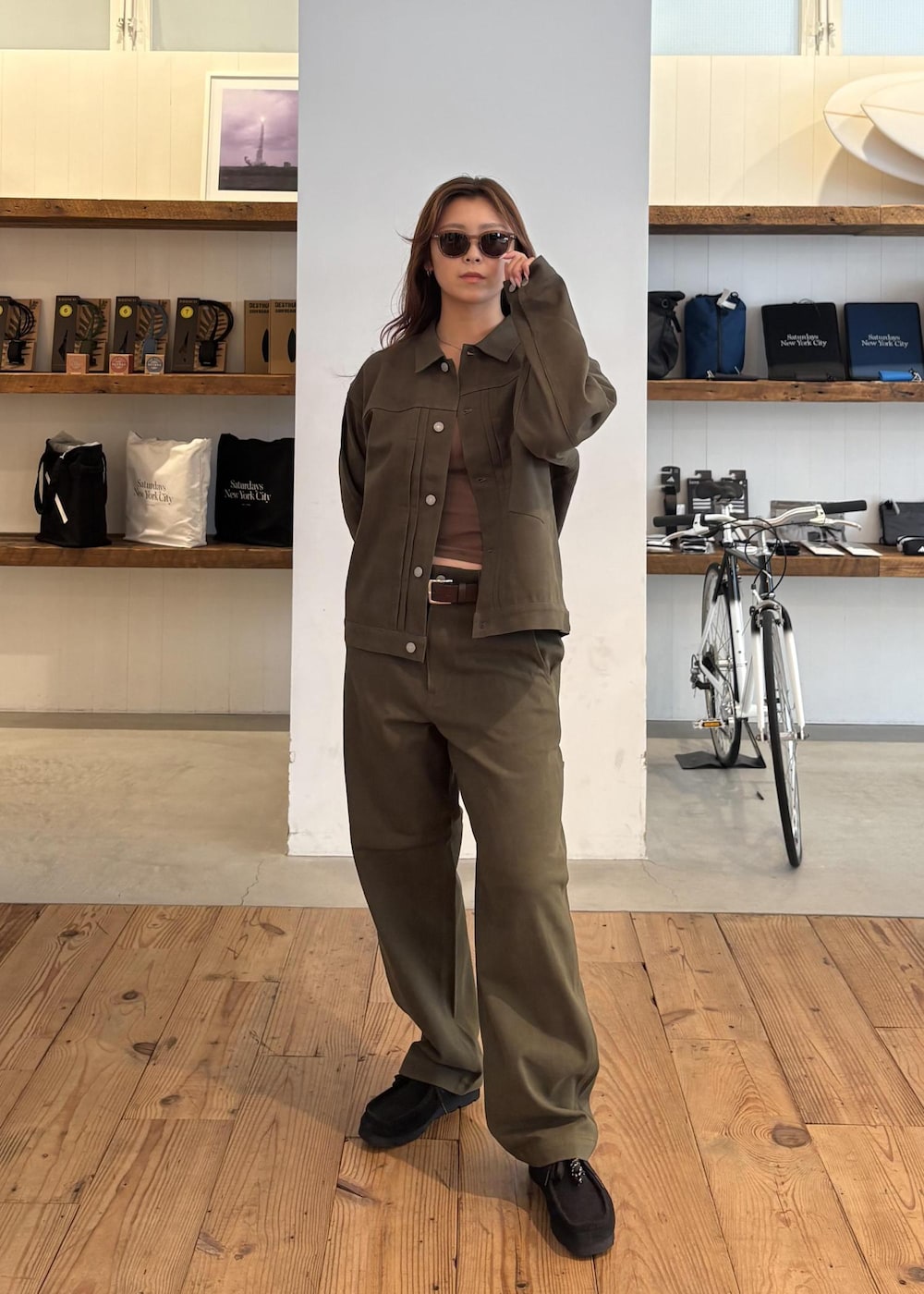 ブラック系のスニーカー、グリーン系のその他パンツ、ブラウン系のベルトを着用したレディースの秋コーディネートの2枚目の写真