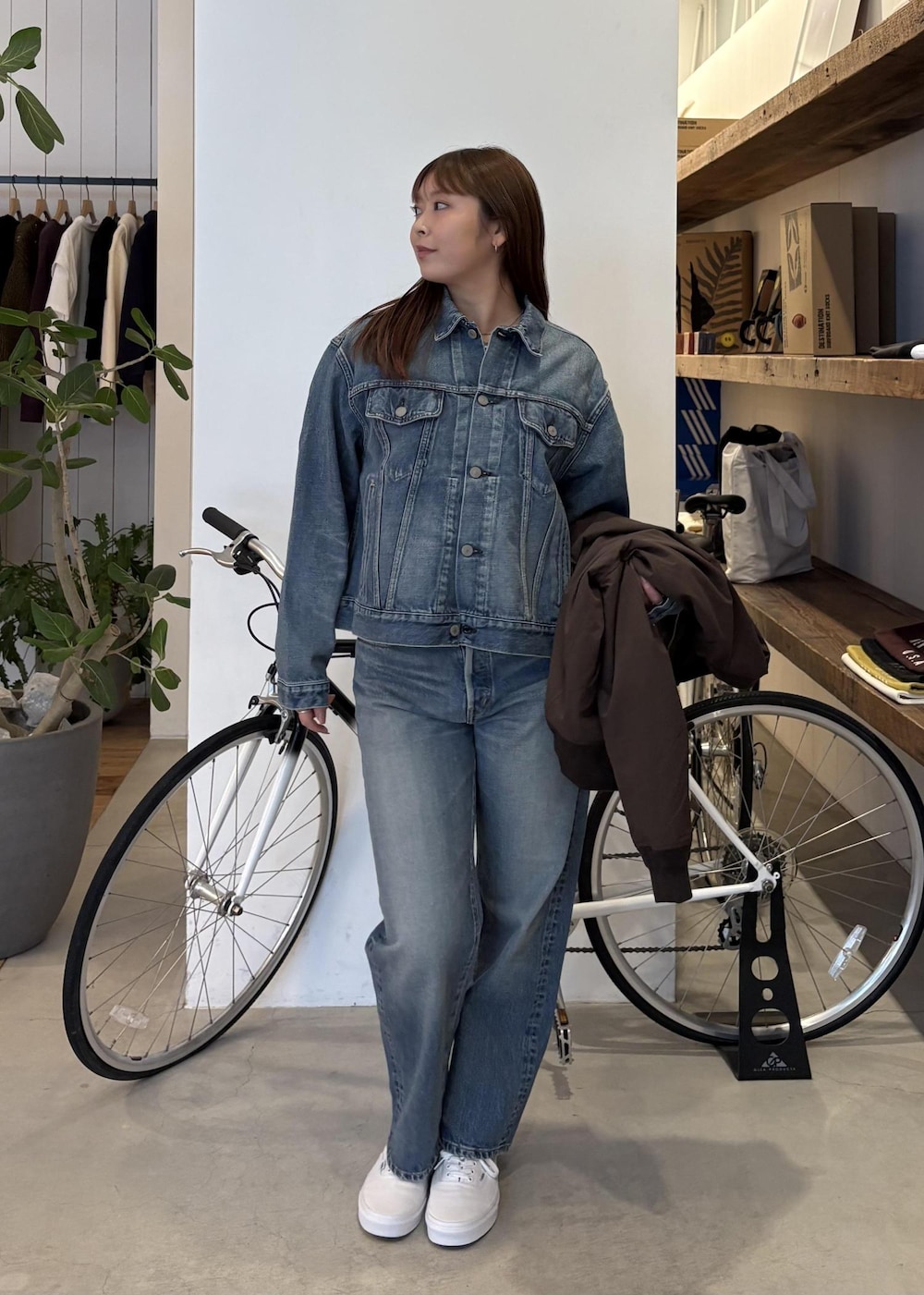 ブルー系のデニムジャケット、ブラウン系のその他アウター、ブルー系のデニムパンツを着用したレディースの冬コーディネートの3枚目の写真