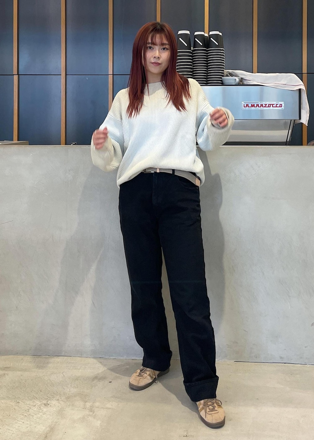 ブラック系のデニムパンツ、ブルー系のニット/セーター、ベージュ系のベルトを着用したレディースの秋コーディネートの2枚目の写真