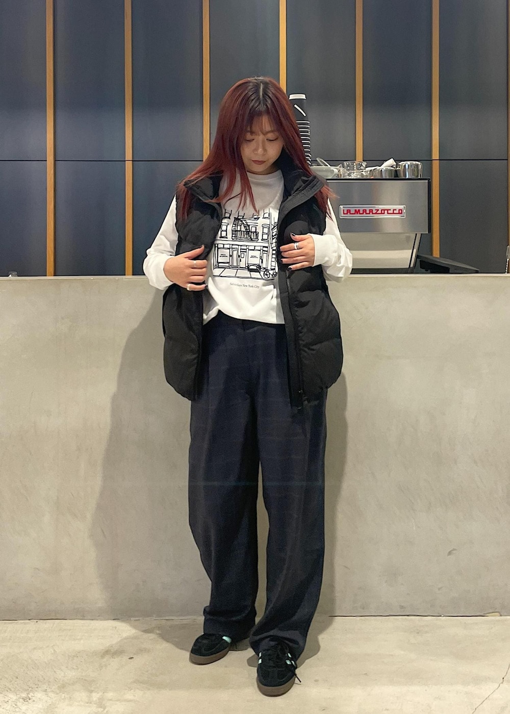 ホワイト系のTシャツ/カットソー、ブラック系のダウンベスト、ブラック系のその他パンツを着用したレディースの秋コーディネートの2枚目の写真