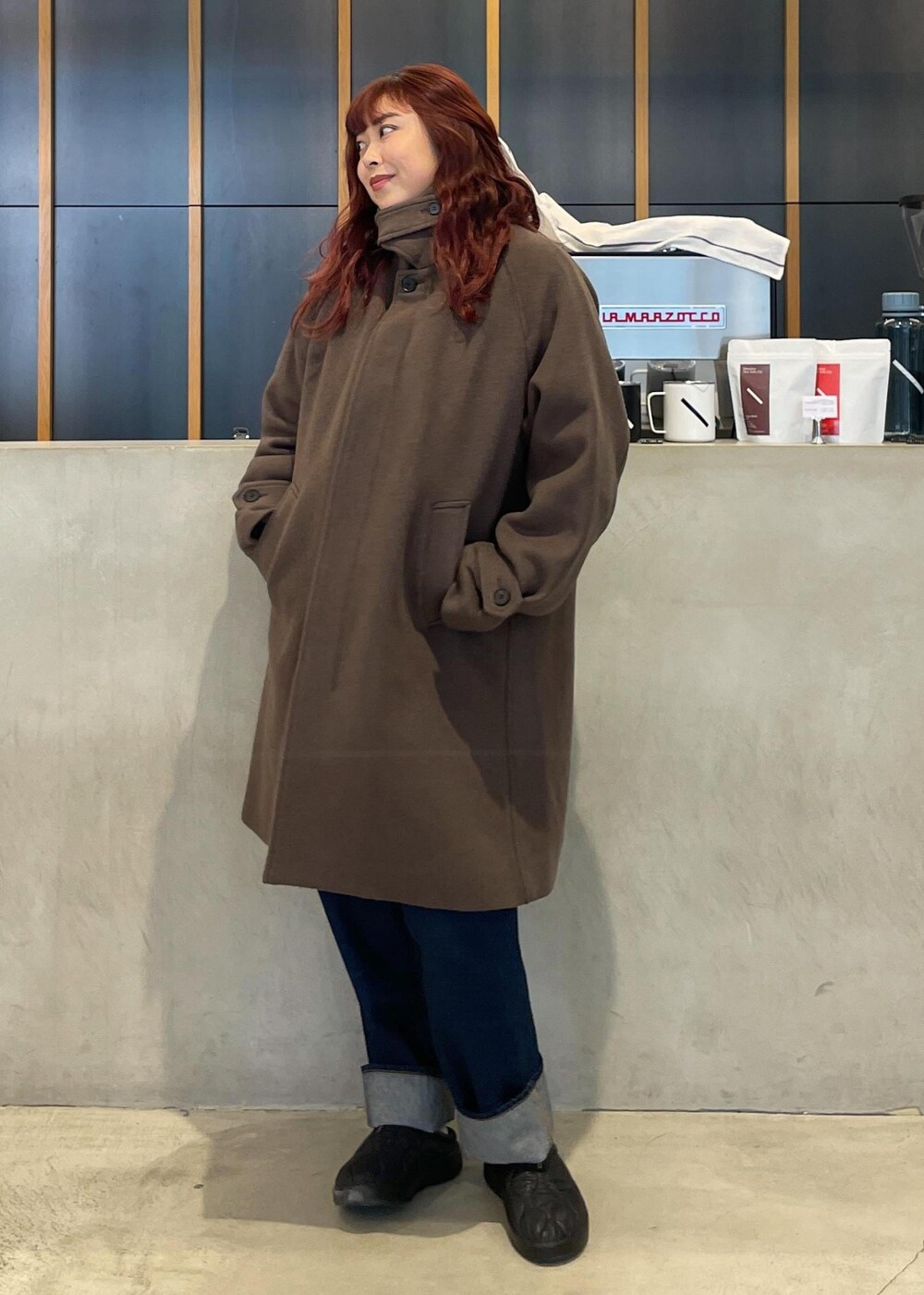 ブルー系のデニムパンツ、ブラック系のサンダル、ブルー系のニットキャップ/ビーニーを着用したレディースの冬コーディネートの4枚目の写真