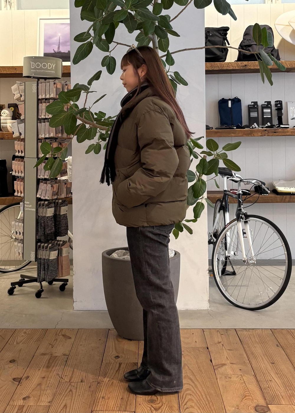 グリーン系のブルゾン、ブラック系のマフラー、ホワイト系のサングラスを着用したレディースの冬コーディネートの4枚目の写真