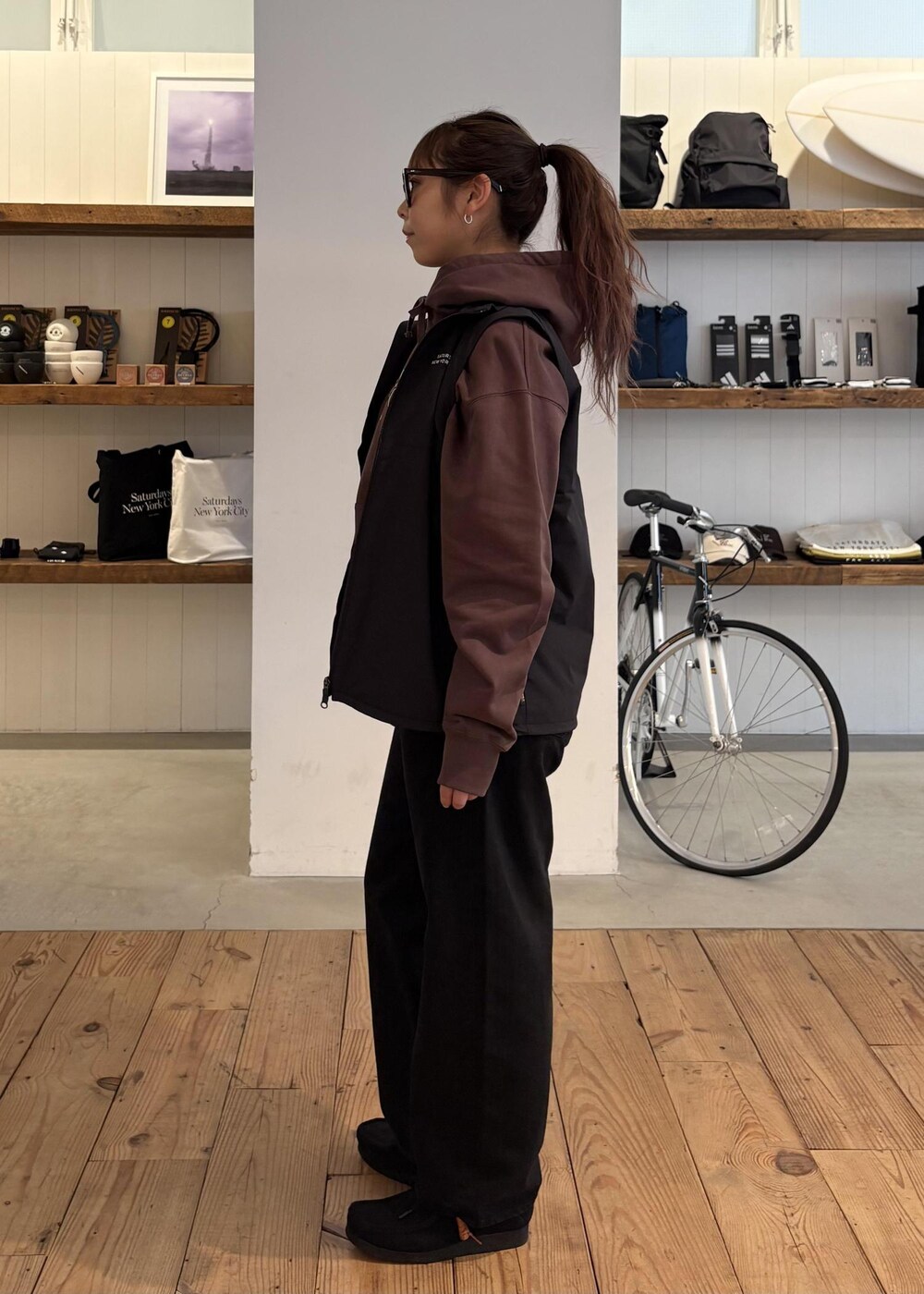 ブラック系のデニムパンツ、グリーン系のダウンジャケット/コート、ブラウン系のパーカーを着用したレディースの冬コーディネートの2枚目の写真