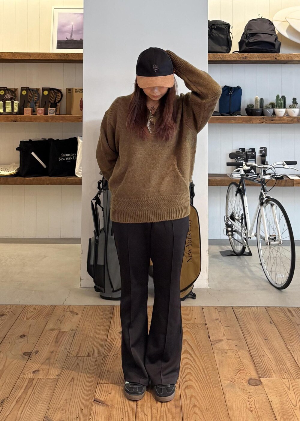 グリーン系のニット/セーター、ブラック系のキャップを着用したレディースの秋コーディネートの4枚目の写真