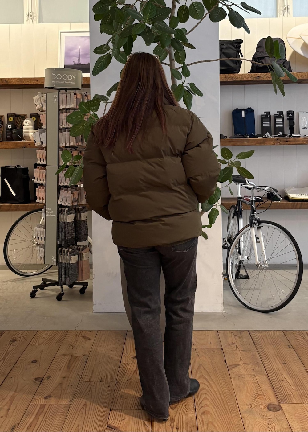 グリーン系のブルゾン、ブラック系のマフラー、ホワイト系のサングラスを着用したレディースの冬コーディネートの5枚目の写真