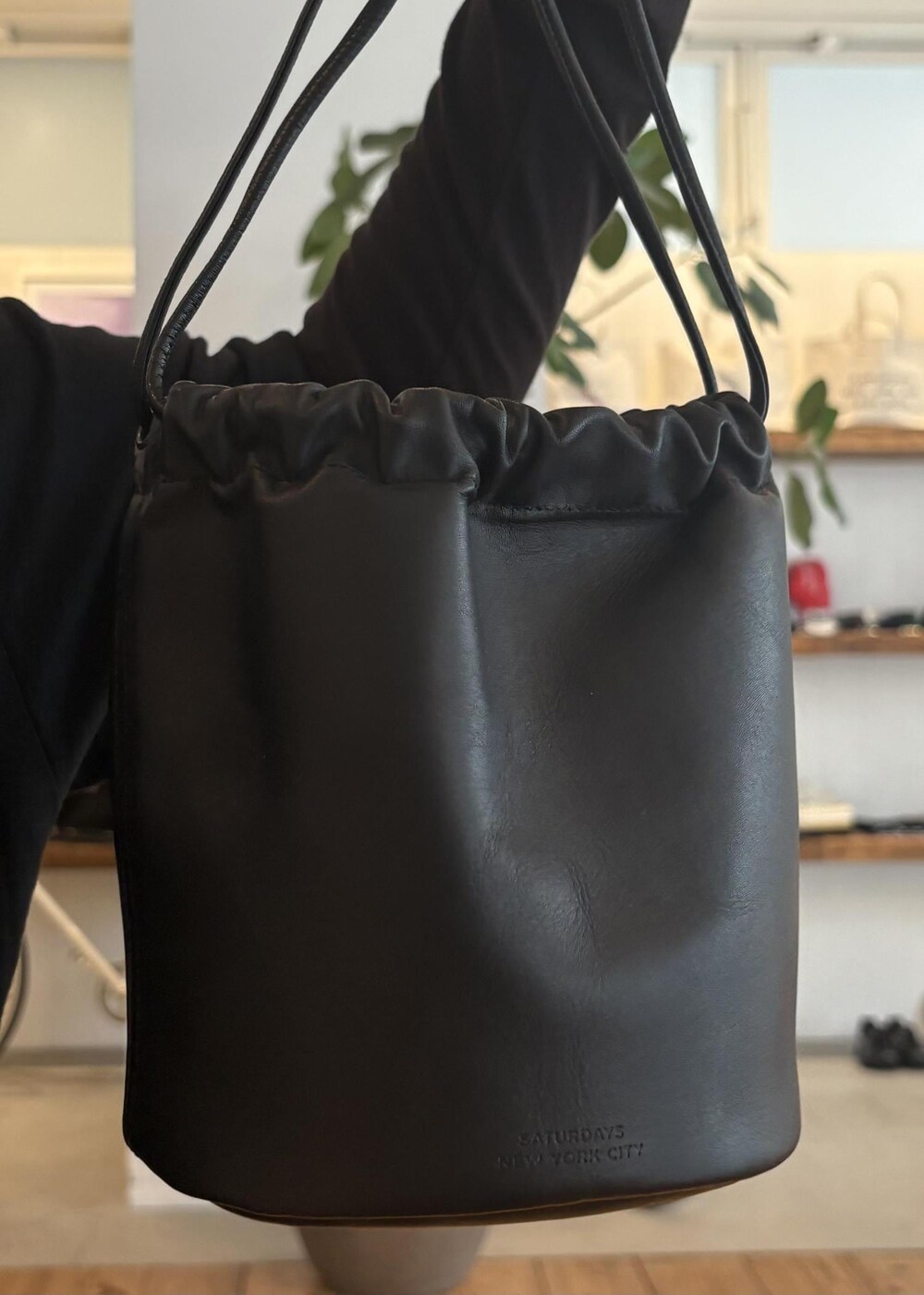 ブラウン系のサンダル、ブラック系のTシャツ/カットソー、ブラック系のハンドバッグを着用したレディースの春コーディネートの7枚目の写真