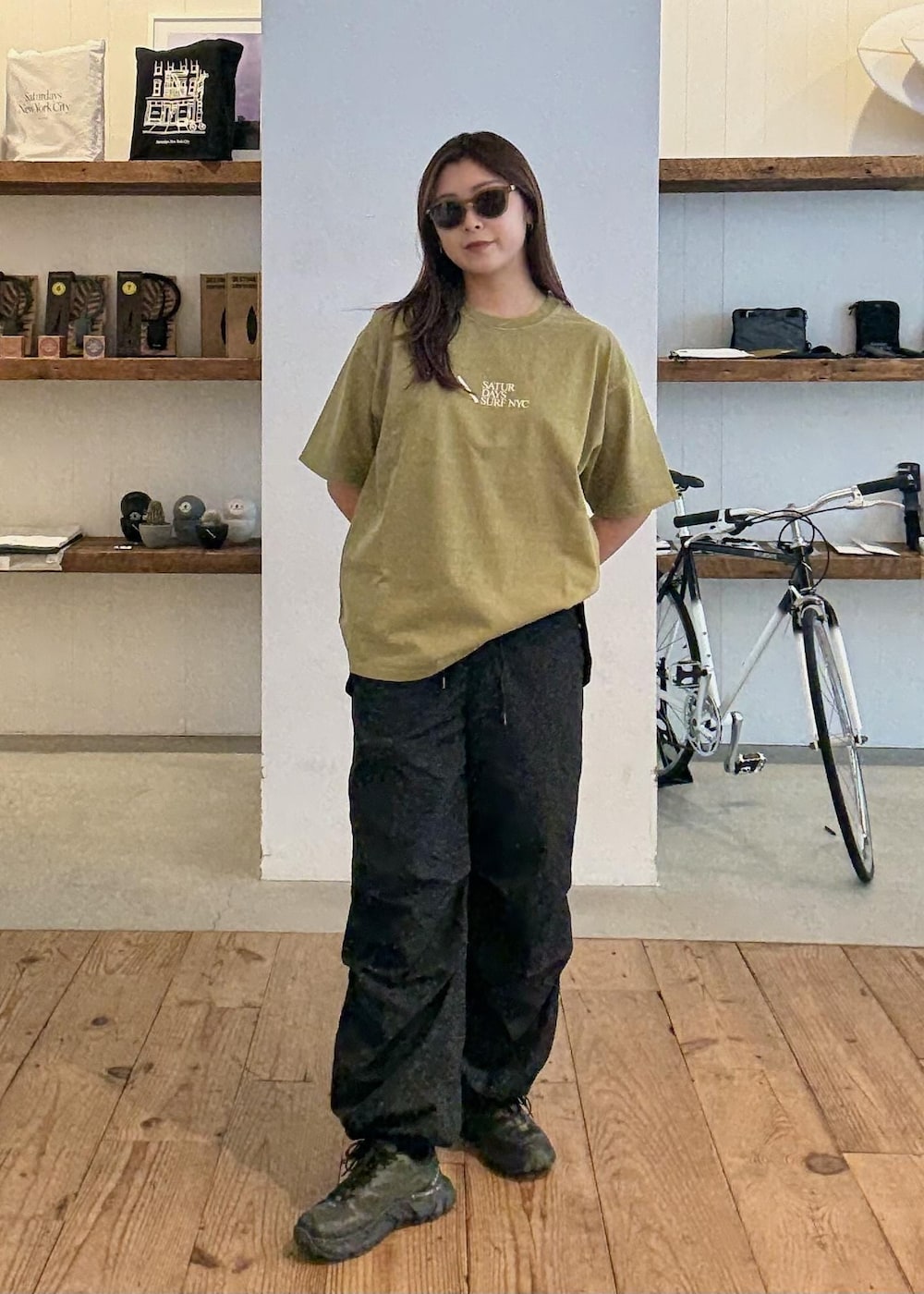 イエロー系のTシャツ/カットソー、ブラック系のその他パンツ、ベージュ系のサングラスを着用したレディースの夏コーディネートの3枚目の写真