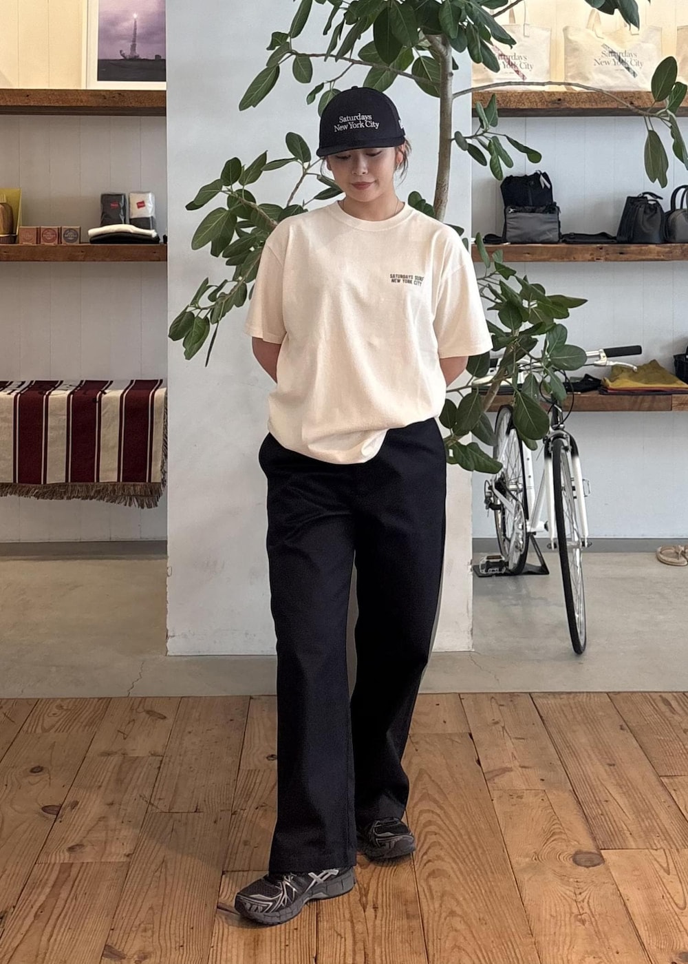ホワイト系のTシャツ/カットソー、ブルー系のチノパンツ、ブルー系のキャップを着用したレディースの夏コーディネートの2枚目の写真
