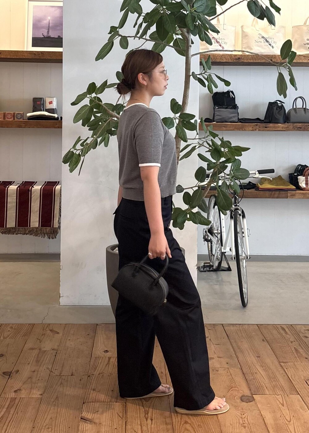 ブラック系のハンドバッグ、ブルー系のチノパンツ、グレー系のTシャツ/カットソーを着用したレディースの夏コーディネートの6枚目の写真