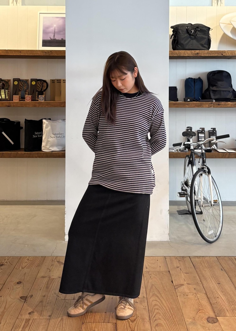 ブルー系のトートバッグ、ブラック系のデニムスカート、グレー系のTシャツ/カットソーを着用したレディースの秋コーディネートの2枚目の写真