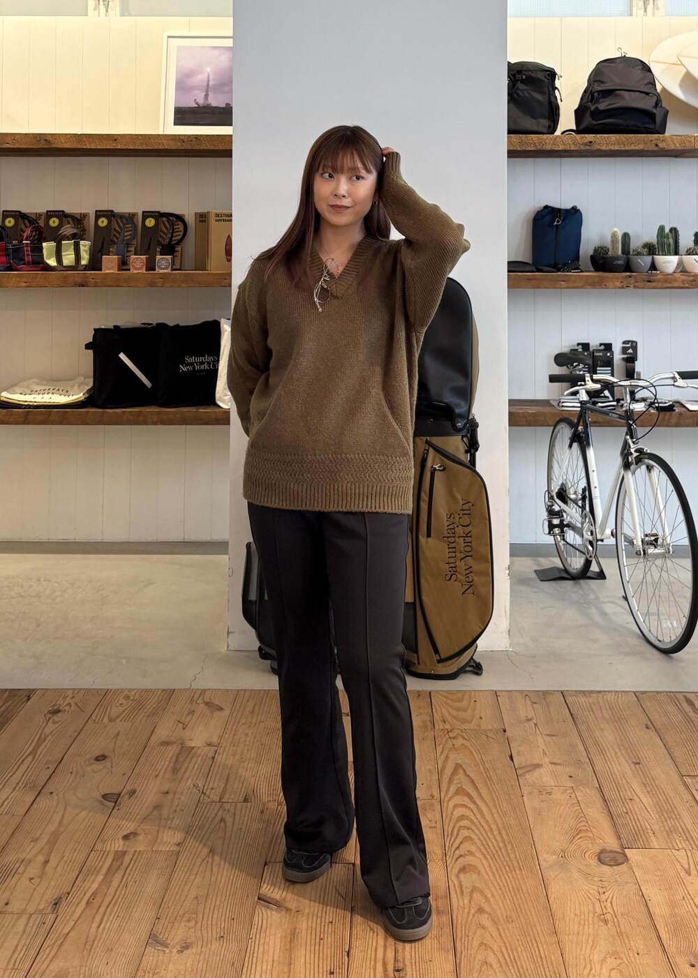 グリーン系のニット/セーター、ブラック系のキャップを着用したレディースの秋コーディネートの5枚目の写真