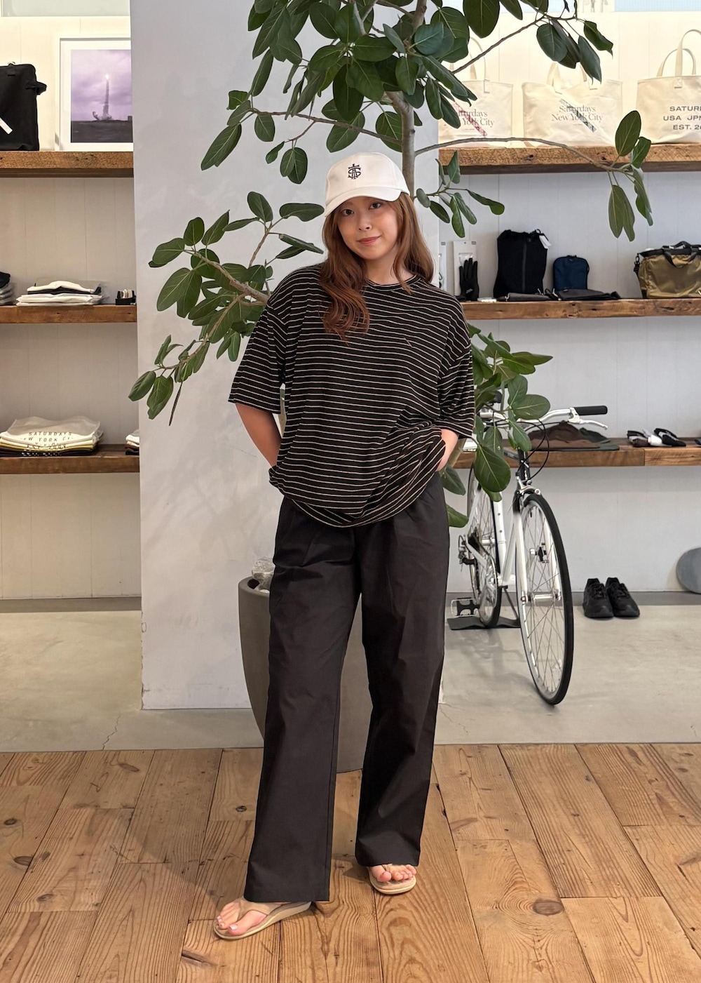 ブラック系のその他パンツ、ブラウン系のTシャツ/カットソー、ホワイト系のキャップを着用したレディースの夏コーディネートの2枚目の写真