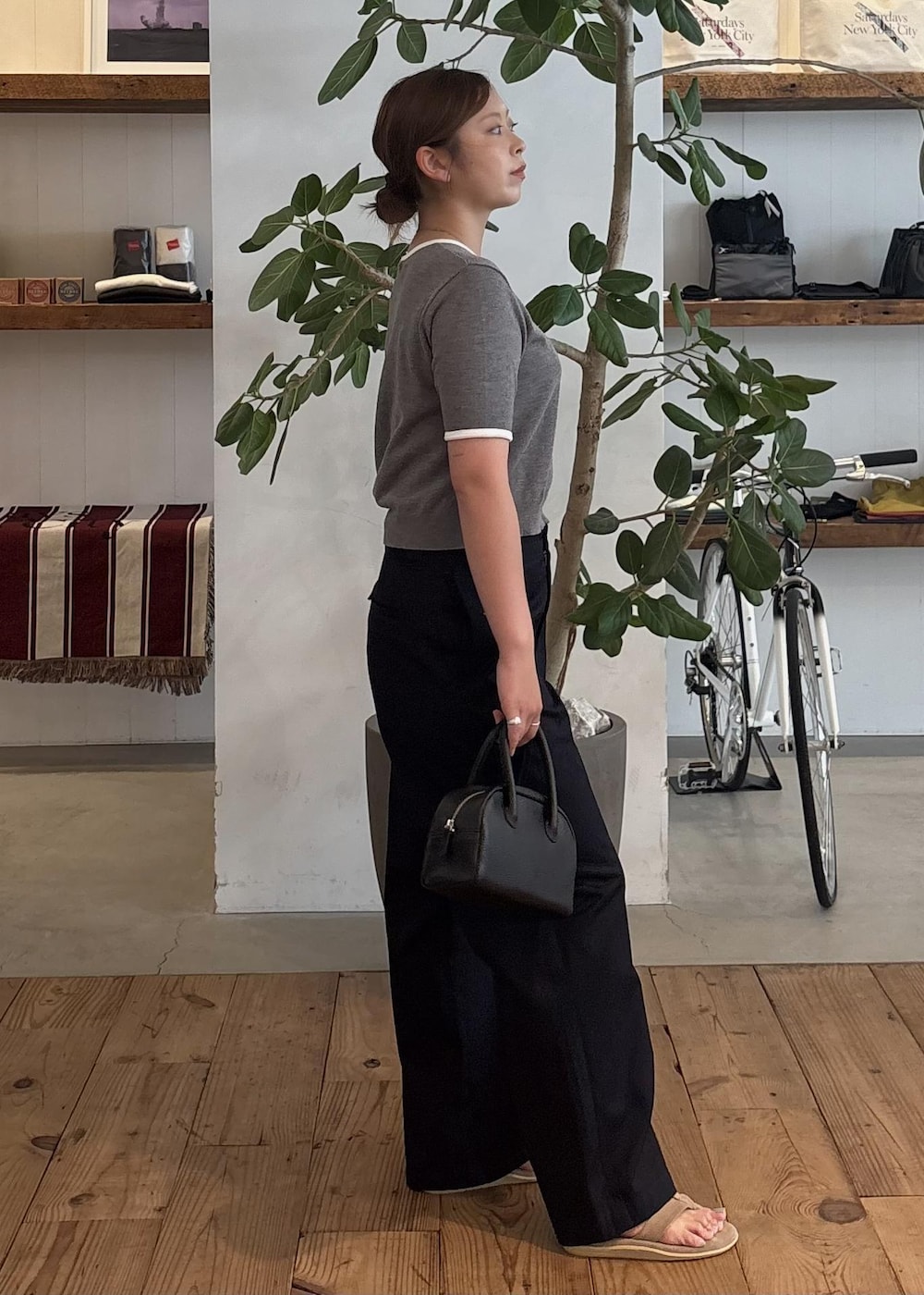 ブラック系のハンドバッグ、ブルー系のチノパンツ、グレー系のTシャツ/カットソーを着用したレディースの夏コーディネートの4枚目の写真