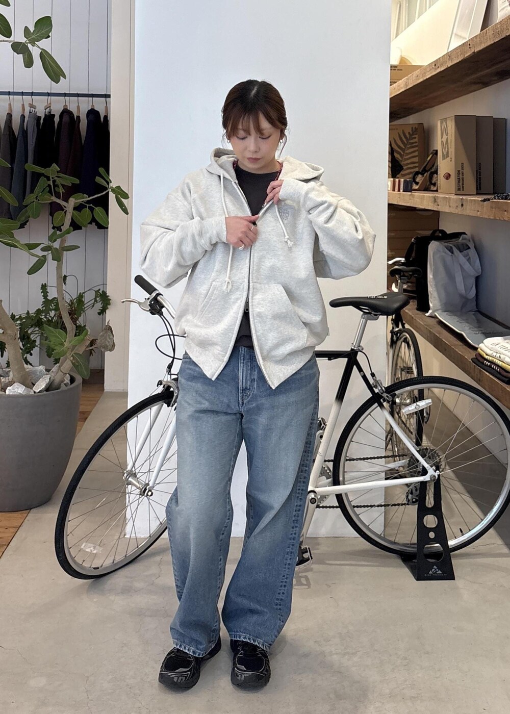 ブルー系のデニムパンツ、ブラック系のTシャツ/カットソー、ホワイト系のTシャツ/カットソーを着用したレディースの春コーディネートの2枚目の写真
