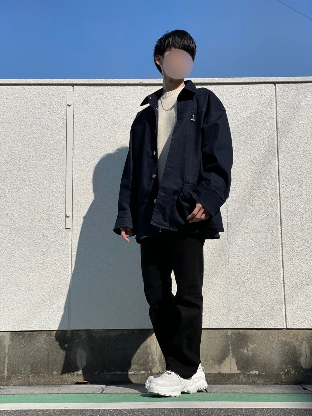 ブルー系のブルゾン、ホワイト系のニット/セーター、ブラック系のデニムパンツを着用したメンズの秋コーディネートの3枚目の写真
