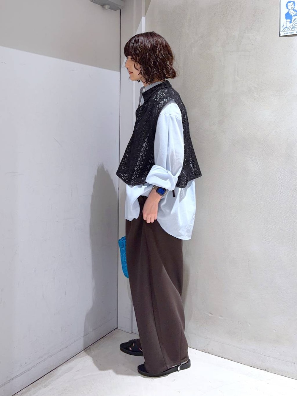 ブルー系のシャツ/ブラウス、ホワイト系のTシャツ/カットソー、ブルー系のクラッチバッグを着用したレディースの夏コーディネートの4枚目の写真