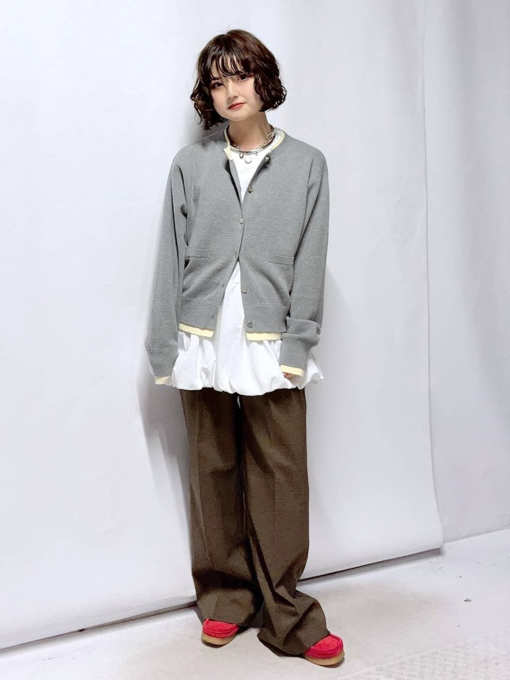 ブラウン系のその他パンツ、ホワイト系のTシャツ/カットソー、グレー系のカーディガン/ボレロを着用したレディースの冬コーディネートの2枚目の写真