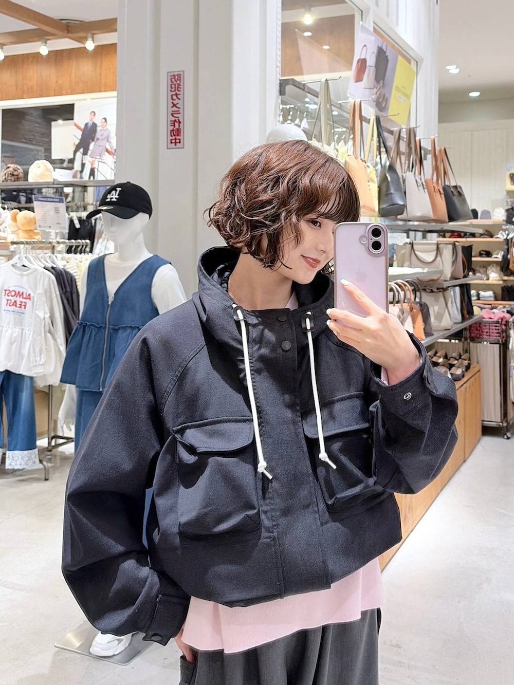 ピンク系のニット/セーター、ブルー系のマウンテンパーカー、グレー系のその他パンツを着用したレディースの春コーディネートの4枚目の写真