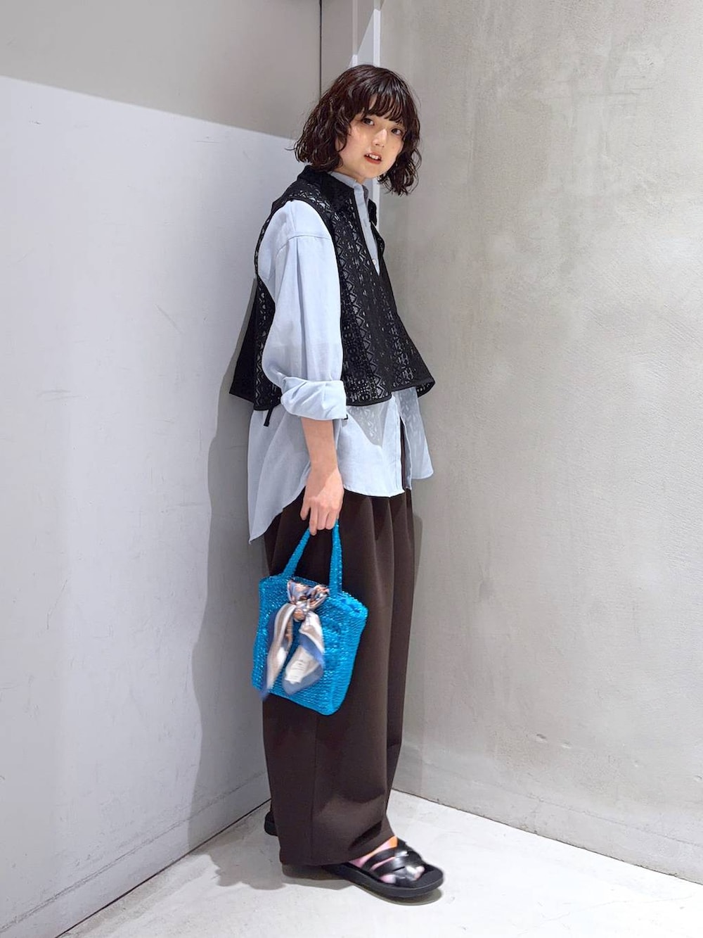 ブルー系のシャツ/ブラウス、ホワイト系のTシャツ/カットソー、ブルー系のクラッチバッグを着用したレディースの夏コーディネートの3枚目の写真