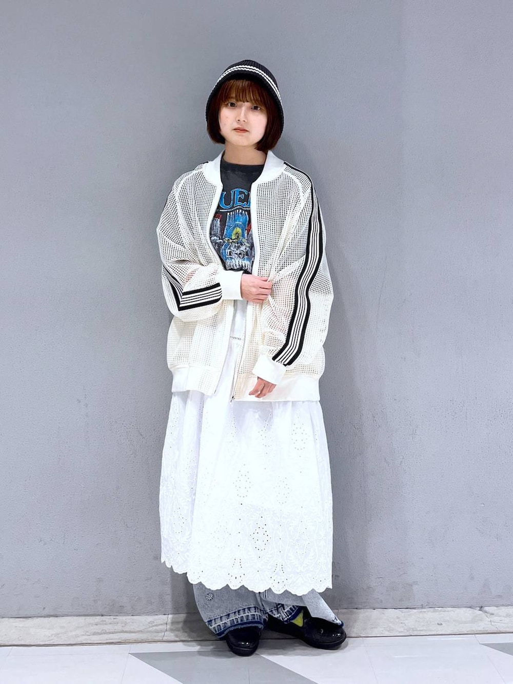 ホワイト系のブルゾン、ブラック系のTシャツ/カットソー、ホワイト系のスカートを着用したレディースの春コーディネートの2枚目の写真