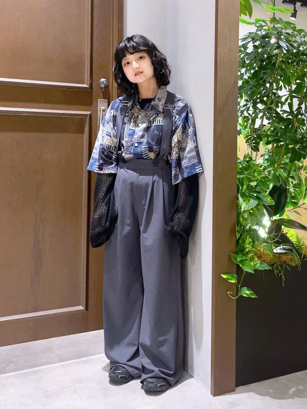 ブルー系のシャツ/ブラウス、グレー系のスラックス、ブラック系のニット/セーターを着用したレディースの春コーディネートの3枚目の写真