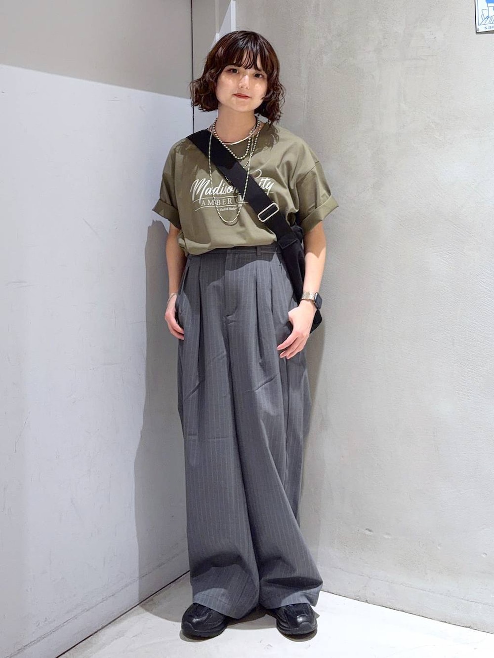 ブラック系のショルダーバッグ、グリーン系のTシャツ/カットソー、ブラック系のスニーカーを着用したレディースの夏コーディネートの6枚目の写真