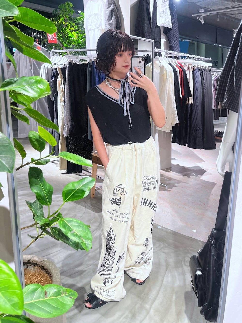 ブラック系のニット/セーター、ホワイト系のチノパンツ、ホワイト系のネックレスを着用したレディースの夏コーディネートの2枚目の写真