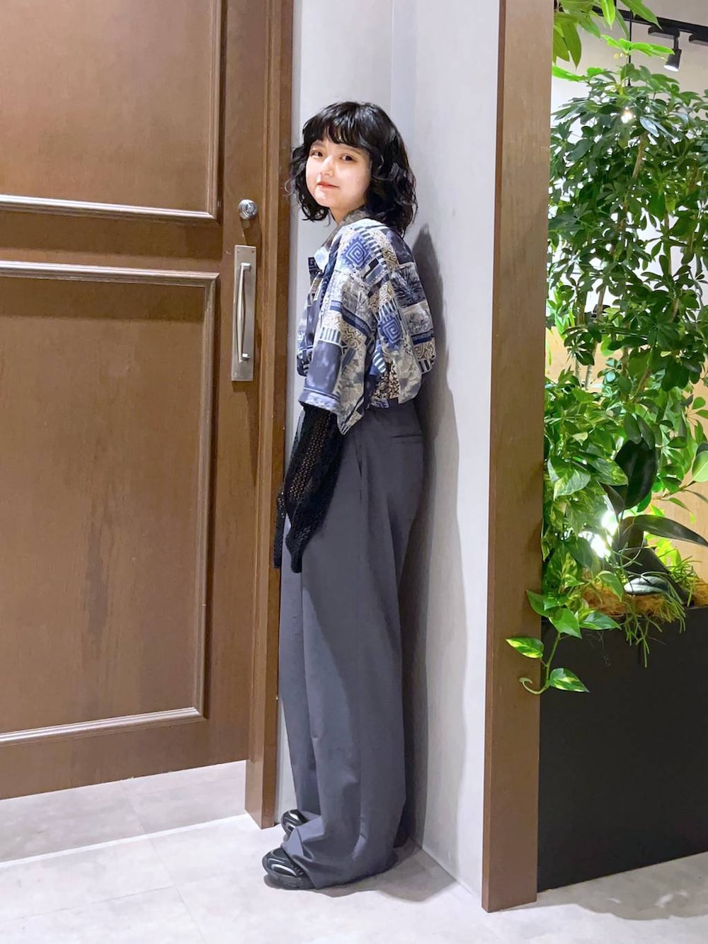 ブルー系のシャツ/ブラウス、グレー系のスラックス、ブラック系のニット/セーターを着用したレディースの春コーディネートの4枚目の写真