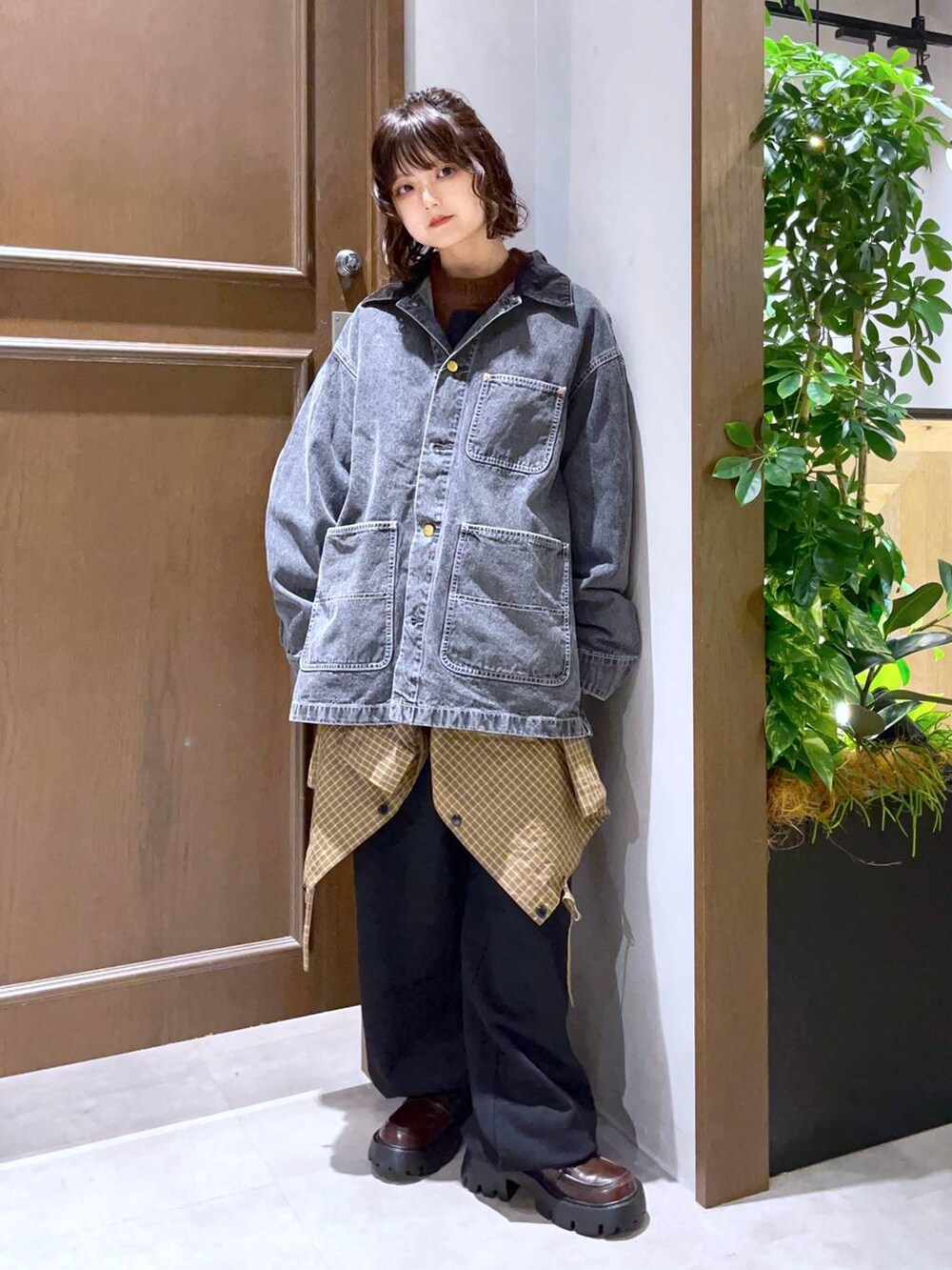 グレー系のブルゾン、イエロー系のシャツ/ブラウス、ブラウン系のニット/セーターを着用したレディースの秋コーディネートの2枚目の写真