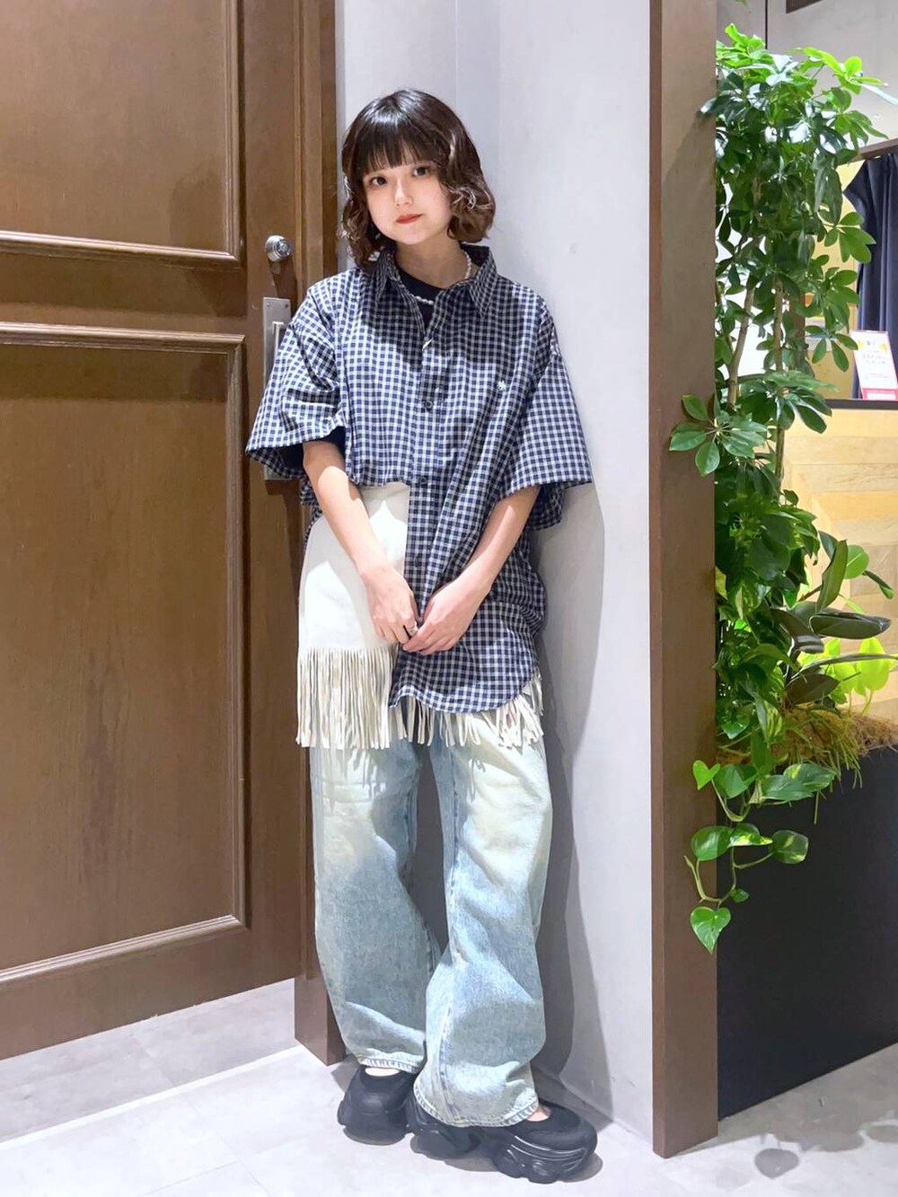 ブラック系のTシャツ/カットソー、ブラック系のサンダル、ホワイト系のスカートを着用したレディースの夏コーディネートの2枚目の写真