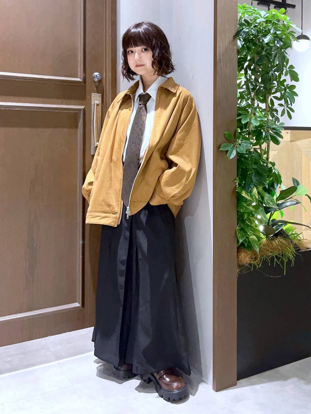 ホワイト系のシャツ/ブラウス、ブラック系のスカート、ブラウン系のブルゾンを着用したレディースの秋コーディネートの2枚目の写真