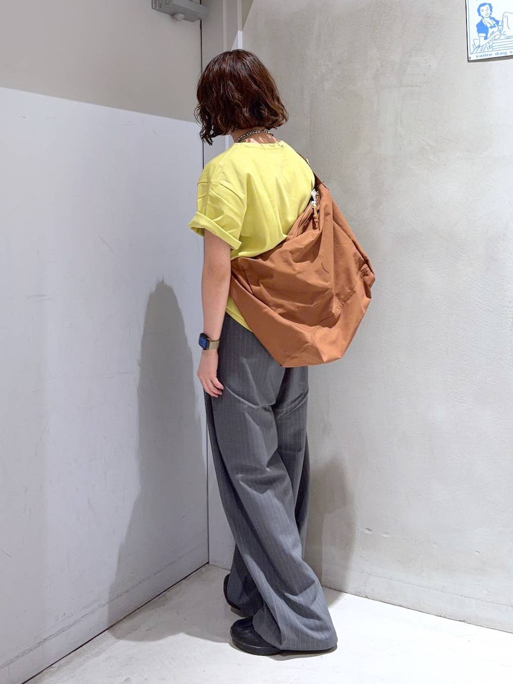 ブラック系のショルダーバッグ、グレー系のその他パンツ、イエロー系のTシャツ/カットソーを着用したレディースの夏コーディネートの5枚目の写真