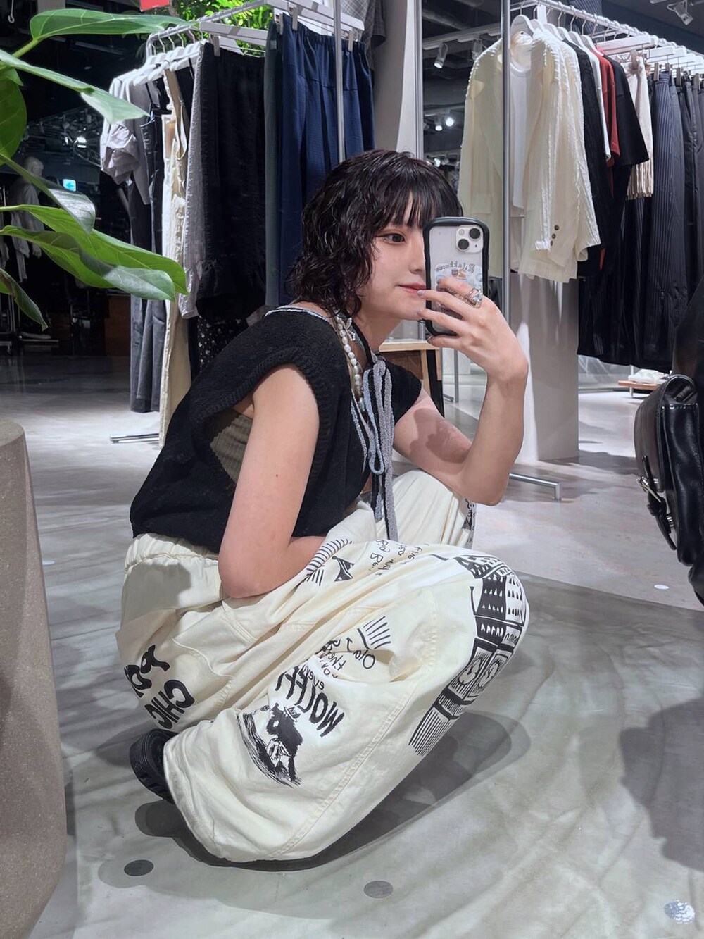 ブラック系のニット/セーター、ホワイト系のチノパンツ、ホワイト系のネックレスを着用したレディースの夏コーディネートの3枚目の写真