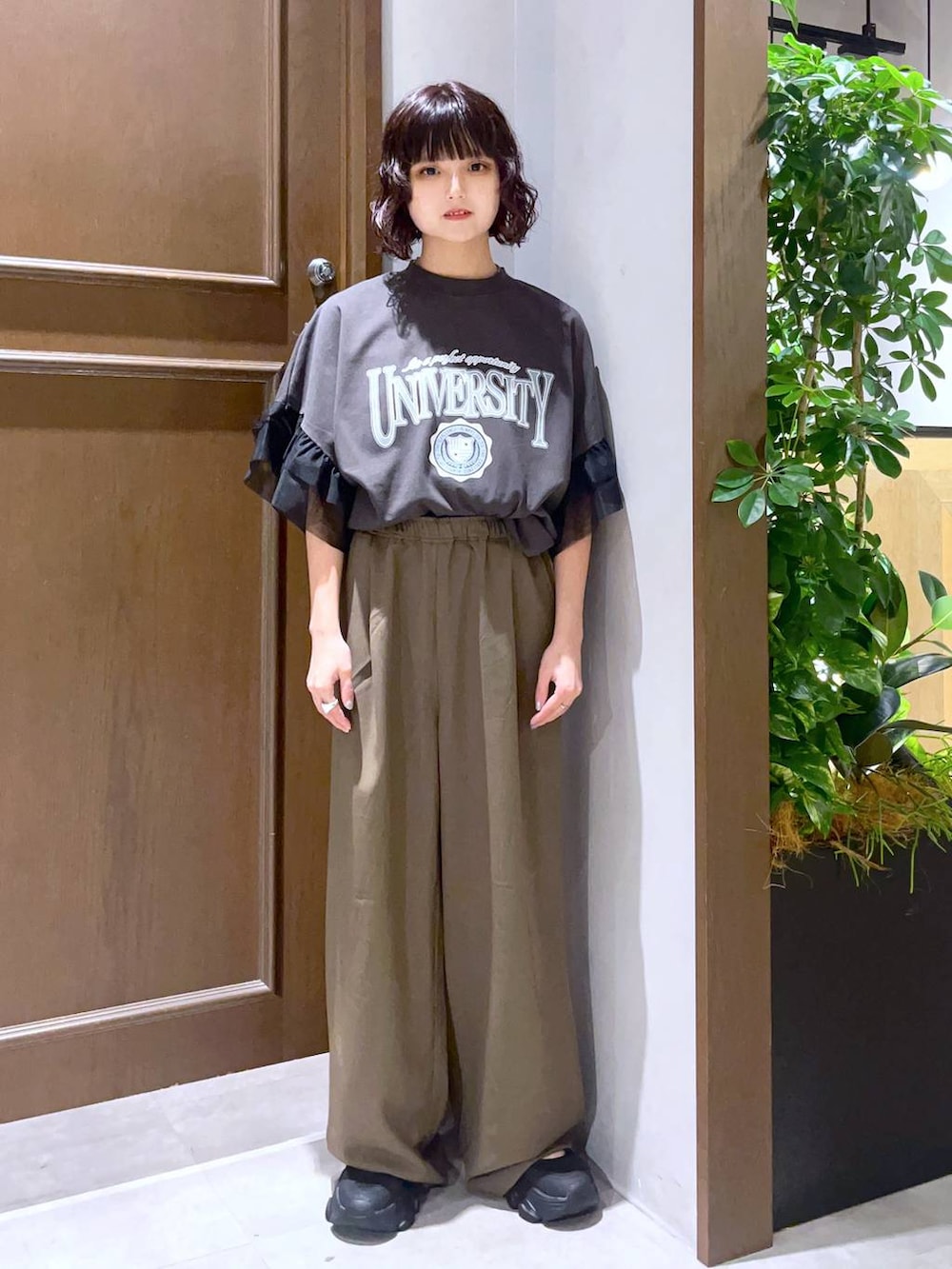 ブラック系のサンダル、ブラック系のTシャツ/カットソー、ブラウン系のスラックスを着用したレディースの夏コーディネートの2枚目の写真