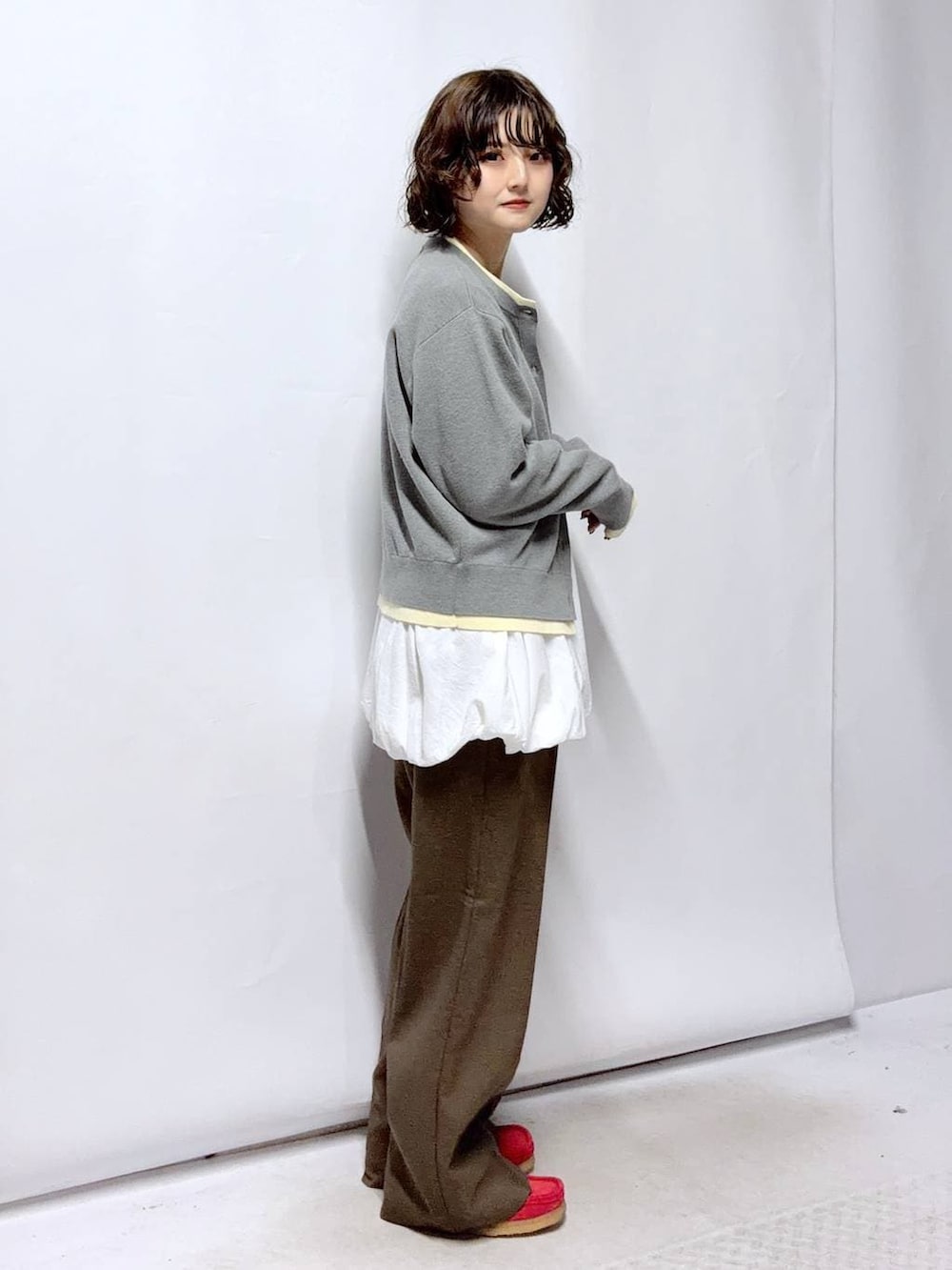 ブラウン系のその他パンツ、ホワイト系のTシャツ/カットソー、グレー系のカーディガン/ボレロを着用したレディースの冬コーディネートの3枚目の写真