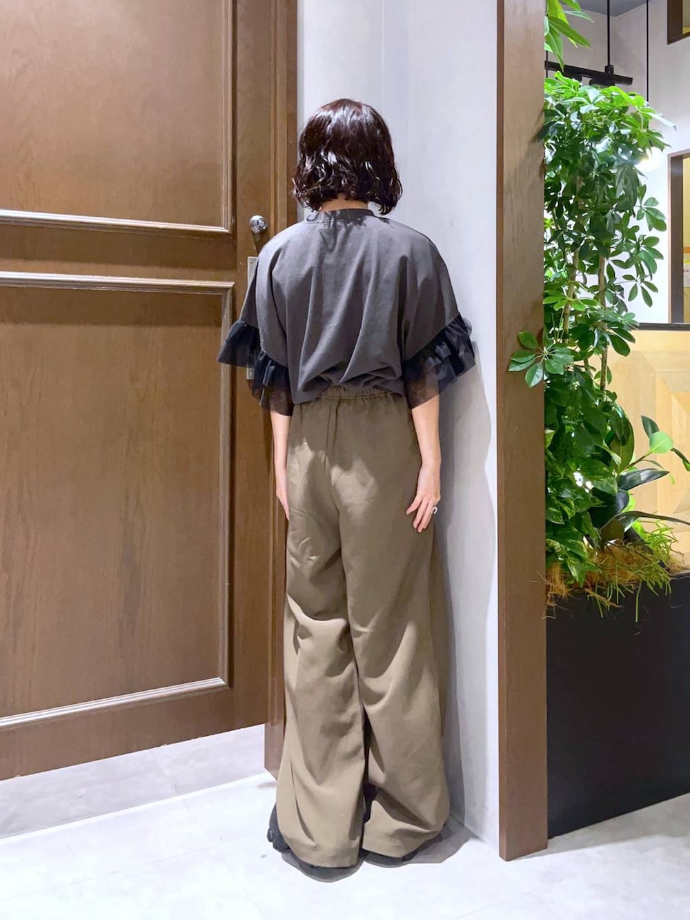 ブラック系のサンダル、ブラック系のTシャツ/カットソー、ブラウン系のスラックスを着用したレディースの夏コーディネートの4枚目の写真