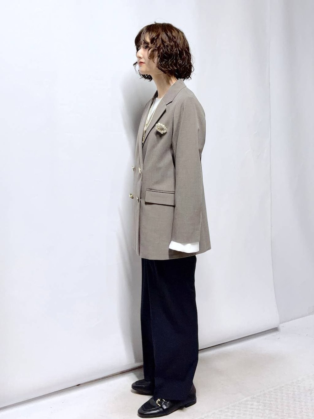 ブラック系のローファー、ブルー系のスラックス、ブラック系のセットアップを着用したレディースの冬コーディネートの3枚目の写真